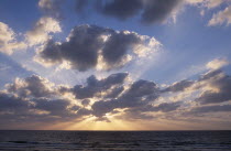 Sunset  with the sun behind a dramatic cloud formation over the Mediterranean Sea