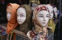 Arabic mannequin heads displaying an array of different headscarves for sale on shop stall