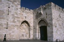 The Jaffa Gate. Orthodox Jewish man walking next to stone walls towards gateThe Jaffa Gate is a stone portal in the historic walls of Jerusalems Old City