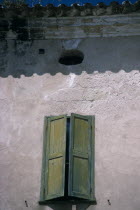 Mahon.  Detail of house facade with green window shutter in Plaza Colon.