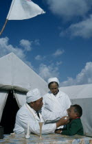 Mountain doctor and nurse treating young boy.Former USSR