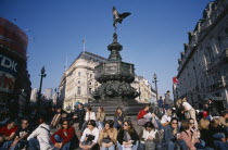 Piccadilly Circus with mixed young crowd congregated around base of Alfred Gilberts statue of Eros