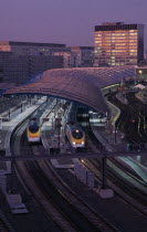 Waterloo Station International Terminal with Eurostar trains in evening.  City buildings behind.