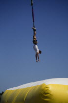 Jumper dangling above large inflatable.