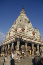 Bungamati Temple exterior with people gathered on the steps and golden spire above