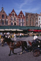 The Markt  Market Place .  Horse drawn carriage passing line of cafes with busy outside tables under green awnings and red umbrellas.