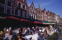 The Markt  Market Place  Line of cafes with busy outside tables under green awnings and red umbrellas.