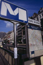 Metro sign at subway entrance with attached poster of missing cat and city map displayed at side.