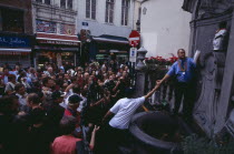 Crowds surrounding the Manneken-Pis statue set up to produce beer.