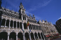 Grand Place.  Maison du Roi exterior with Belgium flag flying from colonnaded facade.