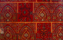 Detail of red door painted with repeated pattern.