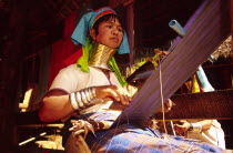 Nai Soi Long neck Karen woman weaving. Nai Soi near the Thai border with Myanmar  is one of several villages where refugee Karen tribals have set up home and use tourism to sustain them. Their necks a...