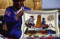 Uros floating islands/Aymara woman. The Aymara women who inhabit the floating reed islands of Uros on Lake Titicaca  make a living from tourism: selling hand made trinkets and patterned wall hangings...