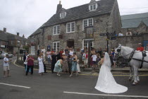 A wedding party gathered on the street taking photographs of the bride near a shire horseGreat Britain United Kingdom Marriage UK
