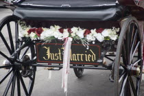 Detail of a Just Married sign on the back of a Horse and carriage decorated with flowersGreat Britain United Kingdom UK