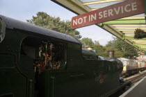 Steam Railway Station. Train waiting in station with a Not in Service sign hanging from covered platformGreat Britain United Kingdom UK