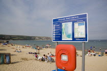 Town Council tourist information sign with busy sandy beach behindGreat Britain United Kingdom UK