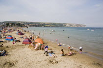Sunbathers on sandy beach with colourful beach tents Great Britain United Kingdom Colorful UK