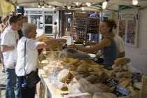 French Market. Selection of breads on stall with customers purchasing from the stallholderGreat Britain United Kingdom UK