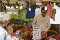 French Market. Selection of sausages on display in baskets on stall with woman purchasing from male stall holderGreat Britain United Kingdom UK