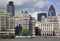 The Gherkin Swiss Re building seen  through tightly huddled buildings in the city  from London Bridge.United Kingdom Great Britain UK