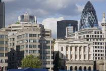 The Gherkin Swiss Re building seen  through tightly huddled buildings in the city  from London Bridge.United Kingdom Great Britain UK