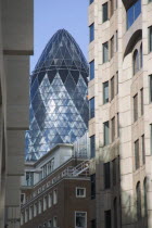 Detail of the top of the Gherkin Swiss RE Building  30 St Mary Axe  seen through narrow city street. Designed by Architect Sir Norman Foster.United Kingdom Great Britain UK