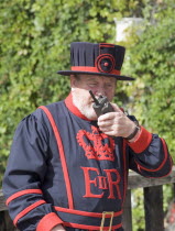 Tower of London guard speaking on walkie talkie. Yeoman Warder BeefeaterUnited Kingdom Great Britain UK