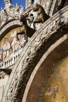 Two of the four bronze Horses of St Mark above the central doorway on the facade of the Basilica Can Marco with its 17th Century religious mosaics