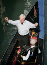 A serenader with an accordian player on a gondola