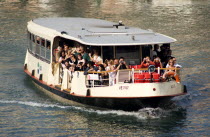 Sightseeing tourists aboard a Vaporetto on the Grand Canal