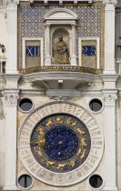 The Madonna on the Torre dellOrologio clock tower above the ornate clock face showing signs of the Zodiac and phases of the moon