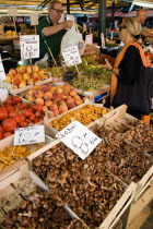 Fruit and vegetable stall in the Rialto market with shopper and vendor