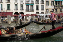 Gondoliers taking tourists on gondola rides on the Grand Canal