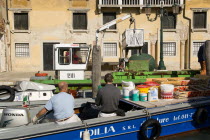 Painters and decorators wait to moor their boat on the Grand Canal whilst a refuse collection boat collects garbage