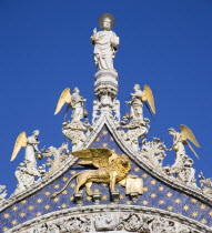 The 15th Century statues of St Mark and Angels over the central arch of St Marks Basilica. The winged Lion of St Mark  the symbol of Venice  stands below the saint