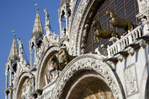 The bronze Horses of St Mark and the 17th Century mosaics on the facade of St Marks Basilica with tourists on the viewing balcony