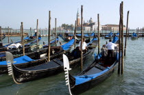 Gondoliers prepare gondolas in the Molo San Marco basin in front of Palladios church of San Giorgio Maggiore on the island of the same name