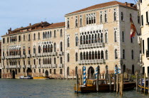 The palace of Ca Foscari on the Grand Canal built for Doge Francesco Foscari in 1437. Now part of the University of Venice. Water taxis moored at wooden posts outside Palazzo Balbi the seat if the reg...