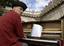 The Paris Plage urban beach. A singer playing a piano to an audience under the Pont Notre Dame on the Voie Georges Pompidou a usually busy road closed to traffic