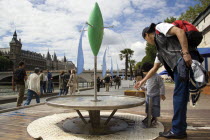 The Paris Plage urban beach. A small boy with an adult at one of the many free drinking water fountains on the Voie Georges Pompidou  a usually busy road now closed to traffic  opposite the Ile de la...