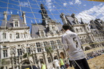 The Paris Plage urban beach. Boy wearing a Zidane football shirt playing in goal during a beach soccer childrens match in front of the Hotel de Ville Town Hall