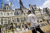 The Paris Plage urban beach. Boy wearing a Zidane football shirt playing in goal during a beach soccer childrens match in front of the Hotel de Ville Town Hall