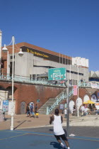Young man playing basketball on the seafront court with the Brighton Centre behind.Center Great Britain United Kingdom