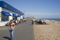 Girl walking past the Babylon Lounge bar on the seafront at Hove.Great Britain United Kingdom