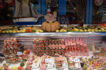 Greek restaurant window display in the Latin Quarter showing seafood and meat kebabs with a pigs head on a plateEuropean French Western Europe