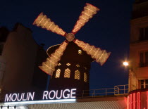 Montmartre The Moulin Rouge nightclub illuminated at night with the windmill sails rotatingEuropean French Nite Western Europe