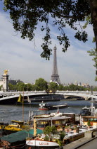 Houseboat barges moored alongside Port des Champs Elysees on the River Seine by the Ponte Alexandre III with the Eiffel Tower in the distanceEuropean French Western Europe