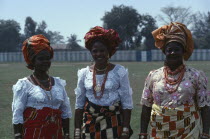 Three-quarter portrait of three Ibo women dressed in traditional clothes for special occasion.  Igbo