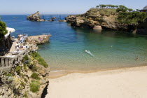 The Basque seaside resort on the Atlantic coast. The Plage de Port-Vieux with a seafood restaurant on a promontory at the end of the beach and the Rocher de la Vierge out to sea